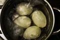 Close-up of boiling eggs in a saucepan boiling water with a soft background