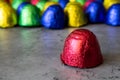 Close-up of bonbon in red wrapping foil in colorful sweets background