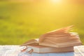 Book and eye glasses on wooden table with abstract blur and bokeh in sunrise or sunset time Royalty Free Stock Photo