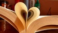 Close-up of the book opened, which the book sheet rolled into a heart shape selective focus and shallow depth of field Royalty Free Stock Photo