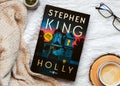 Close-up of the book in spanish Holly by American novelist Stephen King with glasses and coffee Royalty Free Stock Photo