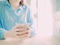 close up both hand hold white hot coffee cup for drink in morning time on table with soft focus background of beauty asian girl i Royalty Free Stock Photo