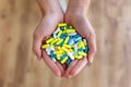 Both hands of young woman holding bunch of pills. Overdose or abuse concept. Royalty Free Stock Photo