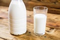Close-up bottle of fresh farm milk and glass of milk on wooden background. Royalty Free Stock Photo