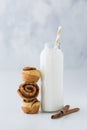 A close up of a bottle of milk with a stack of mini cinnamon buns beside it ready for eating.