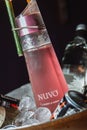 Close up of a bottle of pink Nuvo vodka in a bowl with ice and cans of energy drinks