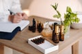 A close-up of bottles of essential oil and an aromatherapist writing a note in a notebook Royalty Free Stock Photo