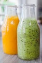 Close up bottles of fruit smoothies. Kiwi. Orange. Royalty Free Stock Photo