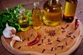 Close-up of bottles with olive oil with spices on a wooden background, cloves of garlic and parsley. Royalty Free Stock Photo