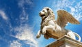 Statue of the Winged Lion of Saint Mark Against a Blue Sky with Clouds - Generative Ai Royalty Free Stock Photo