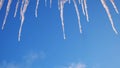 Close up bottom view of melting icicles on blue cloudy sky background. Concept. Early spring natural landscape, end of Royalty Free Stock Photo