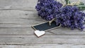 Close up of bouguet of violet purple lavendula lavender flowers herbs with empty wooden pendant and wooden heart, on old rustic wo