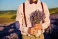Close-up of a bouquet of lavender in the hands of the groom.