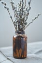 A close-up of a bouquet of willow branches in a brown glass vase as an interior decoration for the Easter holiday.