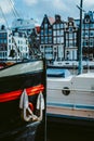 Close-up of the bow front of the wooden ship and anchor. Amsterdam Netherlands dancing houses over river Amstel in the Royalty Free Stock Photo