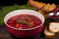 close-up on a bowl of borscht next to a beetroot