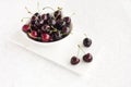 Close-up of a Bowl with Cherries on White Marble Board and Background Royalty Free Stock Photo