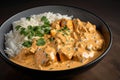 close-up of bowl of chicken tikka masala, with creamy sauce and tender chunks of chicken