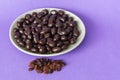 Dried raisins with dark chocolate in a bowl on a purple background Royalty Free Stock Photo