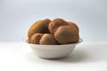 Close-up of a bowl with flat-type kiwis with a neutral background