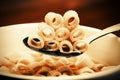 Close up of a bowl of macaroni soup. Spoon picking up macaroni,