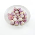 Close up of a bowl of peeled shallots isolate white background