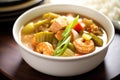 close-up of a bowl of seafood gumbo with shrimp and okra