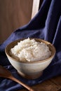 A close-up of a bowl of white rice against a blue fabric background. Royalty Free Stock Photo