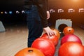 Close up of bowling player hand taking red ball from bowl lift