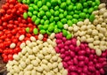 Close up of bowls filled with a large selection of different colored soft candies. Green, White, Red and pink candies