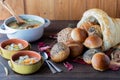 Close up of bowls of turkey soup with a cornucopia made of bread that is filled with a variety of rolls. Royalty Free Stock Photo