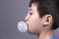 Close up of boy blowing bubble.