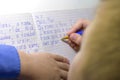 Close-up of boy hand with pencil writing english words by hand on traditional white notepad paper. Royalty Free Stock Photo