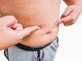 Close-up of boy holding unhealthy big belly with visceral and subcutaneous fats. Pose health risk
