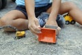CLOSE-UP BOY PLAYING WITH CONSTRUCTION TRUCK, EXCAVATOR TOYS