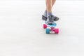 Close up of boy`s feet standing on modern short cruiser skateboa