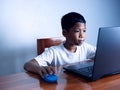 Close up The boy sits staring at the laptop and his hand is holding the mouse. educational concept, educational information search