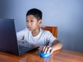 Close up The boy sits staring at the laptop and his hand is holding the mouse. educational concept, educational information search