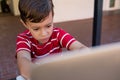 Close up of boy using laptop computer while sitting on chair Royalty Free Stock Photo