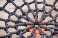 Close-up of braided rope mesh with orange ring in the middle