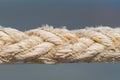 Close up on the braided strands of a rope on grey