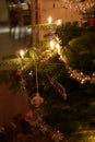 Close-up of a branch of Christmas tree with burning candles, wreath, tinsel colorful baubles Royalty Free Stock Photo