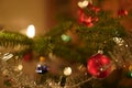 Close-up of a branch of Christmas tree with burning candles, wreath, tinsel colorful baubles Royalty Free Stock Photo