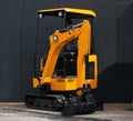 Close up of yellow mini excavator on black wall background Royalty Free Stock Photo