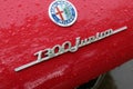 Detail of a red Alfa Romeo Junior with its logo close-up