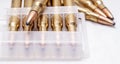 A close up of brass rifle bullets used for hunting, some in a plastic case Royalty Free Stock Photo