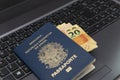 Close up of brazilian passport on laptop with credit cards and cash. Travel planning concept