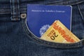 Close up of brazilian work and social security document card in pocket jeans. Real banknotes. Formal employment concept. Translate