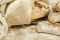 Close-up of bread and buns lying on a wooden table with flour on