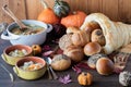 Close up of a bread cornucopia with buns pouring out and bowls of turkey soup, ready for eating.